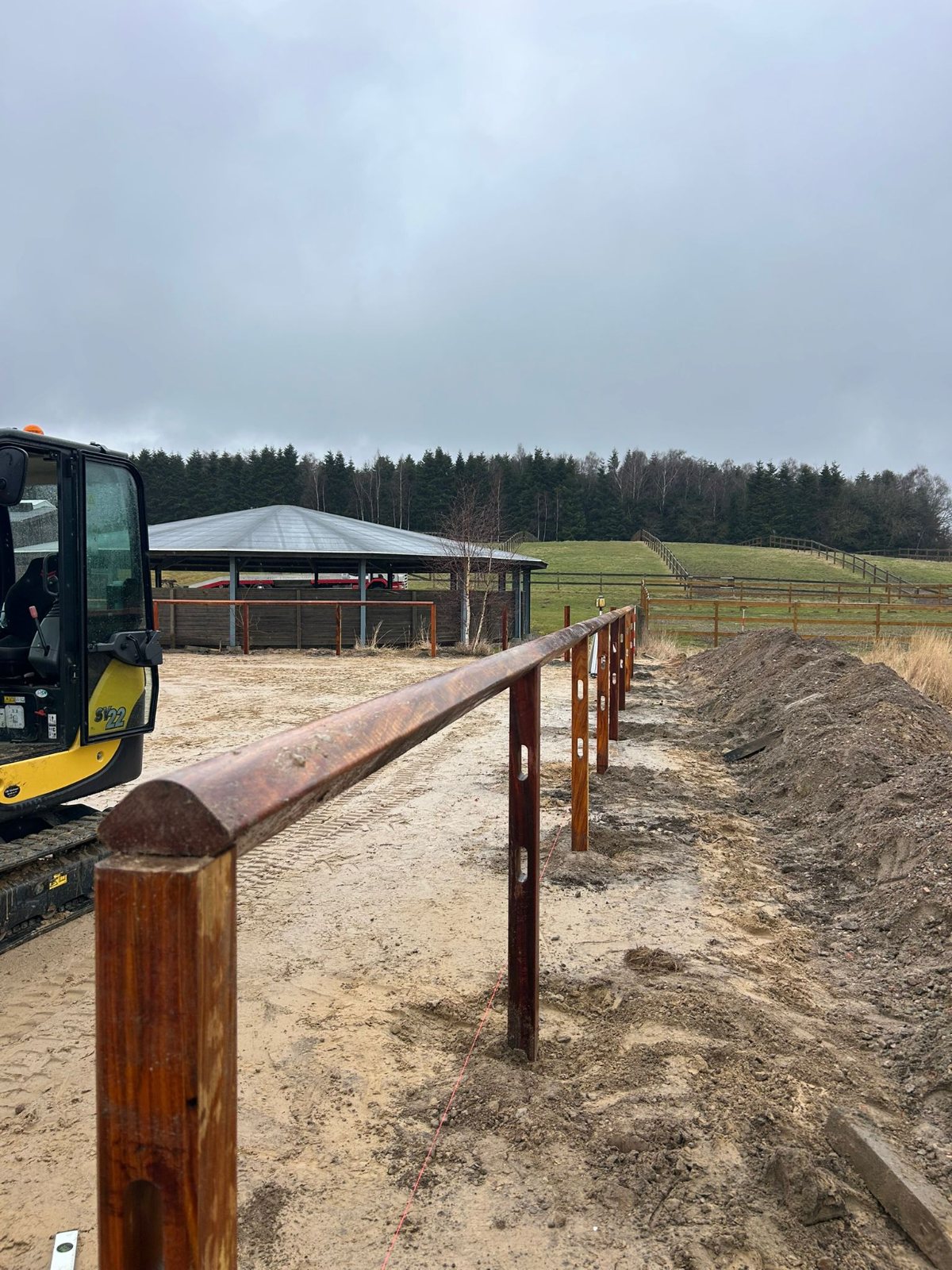 Hardwood fencing around an outdoor riding arena