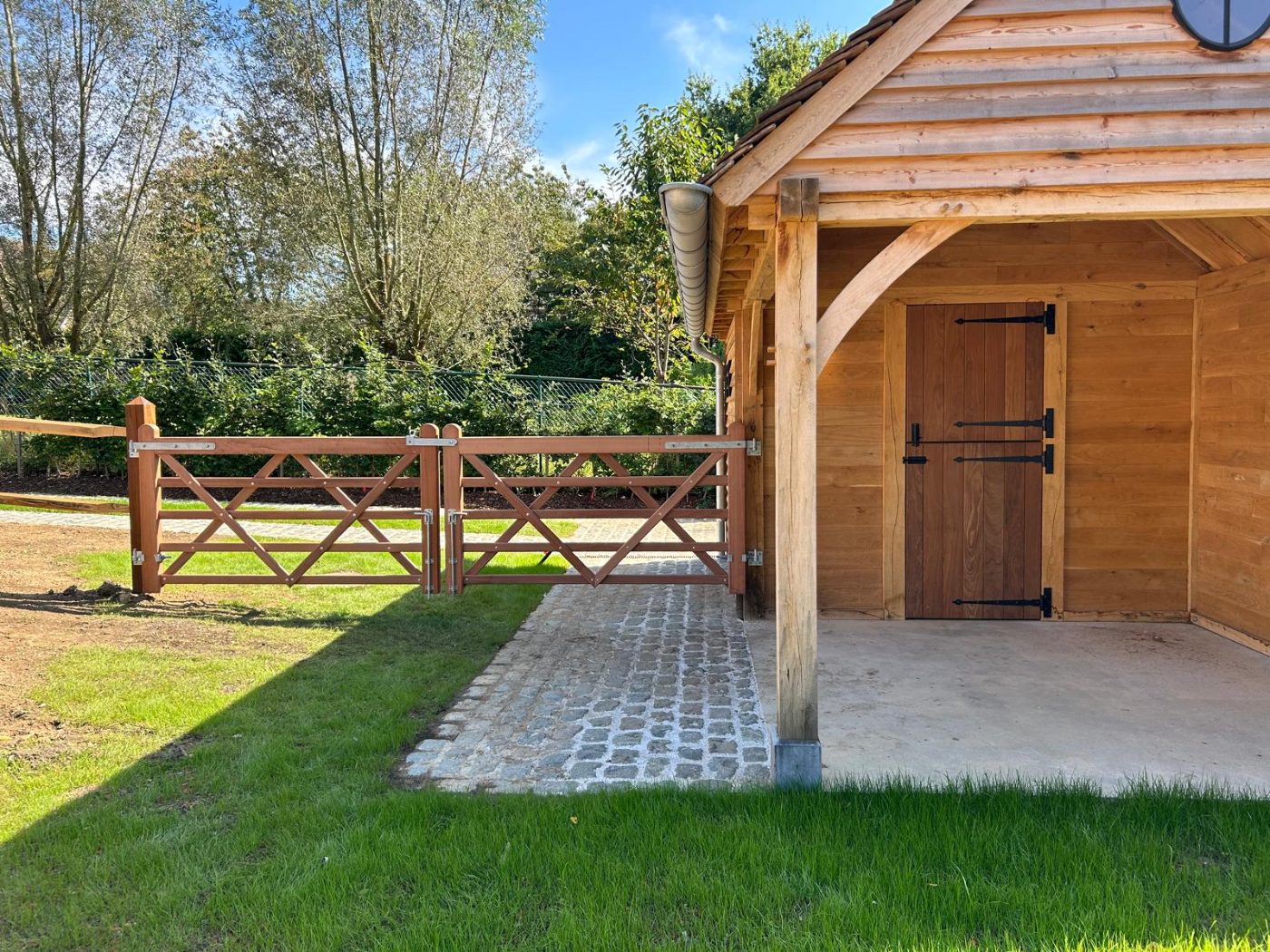 Pair of X-braced hardwood gates at an oak-framed stable